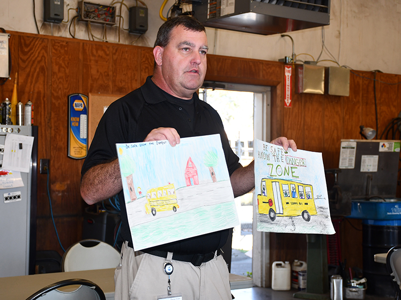 Fannin County School System Transportation Director Denver Foster displays two of the Fire Safety Week Posters from Fannin County that will move on in the state’s competition.