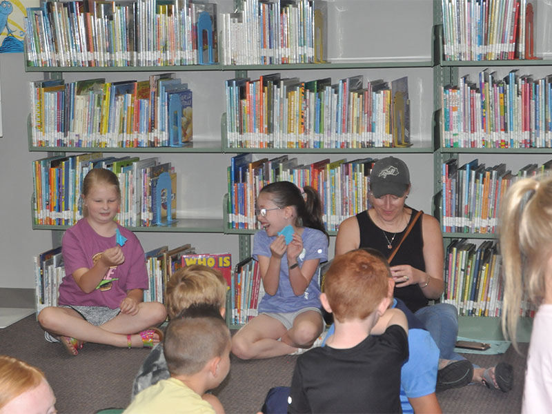 Friends, Olivia Edwards, left, and Zoë Ethington show each other their origami fireflies they made at Fantastic Fireflies during the Summer Reading Program at the Fannin County Public Library last week. 