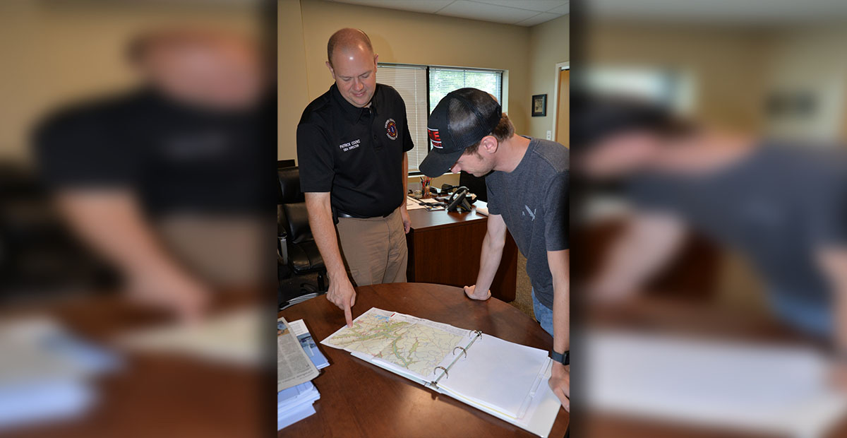 Fannin County EMA Director Patrick Cooke, left, and firefighter Trent Lowery look over TVA maps depicting the results of a catastrophic failure of Blue Ridge Dam. TVA maintains the dam is safe as it prepares for its Thursday, June 27, siren test.