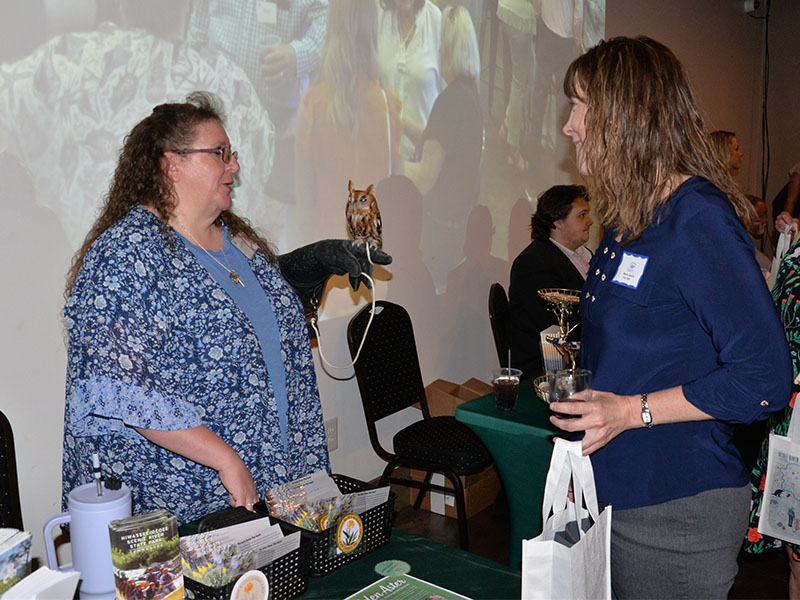 RIGHT: Manda Gwatney, right, visits with an exhibit featuring a blind owl during the kickoff event for TVA’s Ocoee Whitewater Rafting & Fly Fishing Experience.